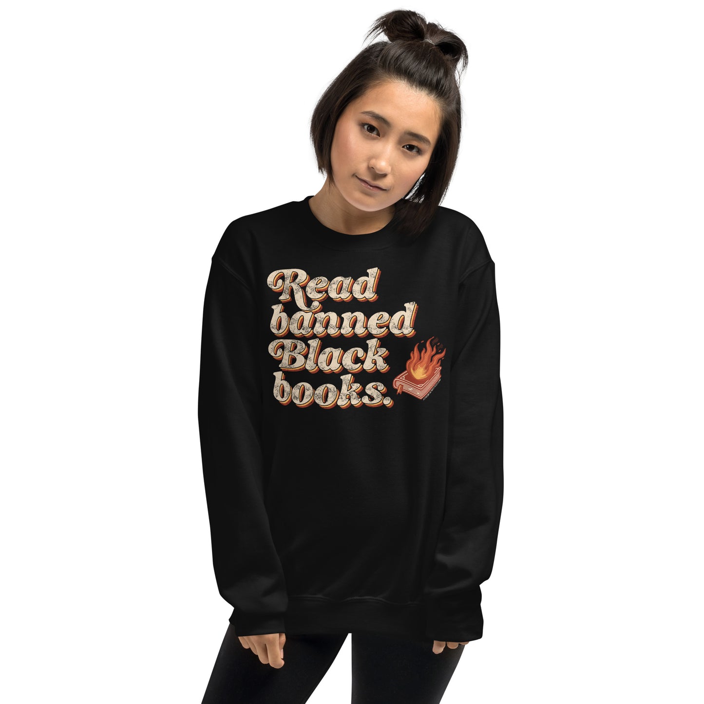 Young woman in a black 'Read Banned Black Books' sweatshirt with bold text and a flaming book graphic, combining comfort and cultural advocacy.