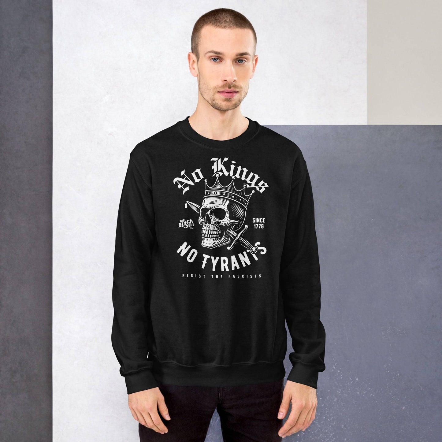Male model in black No Kings No Tyrants Skull Protest Sweatshirt, featuring bold anti-fascist message and skull graphic by TheBlackest Co.