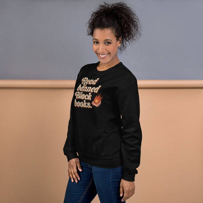 Woman smiling in a black 'Read Banned Black Books' sweatshirt, showcasing bold lettering and a flaming book design, perfect for casual wear and cultural pride.