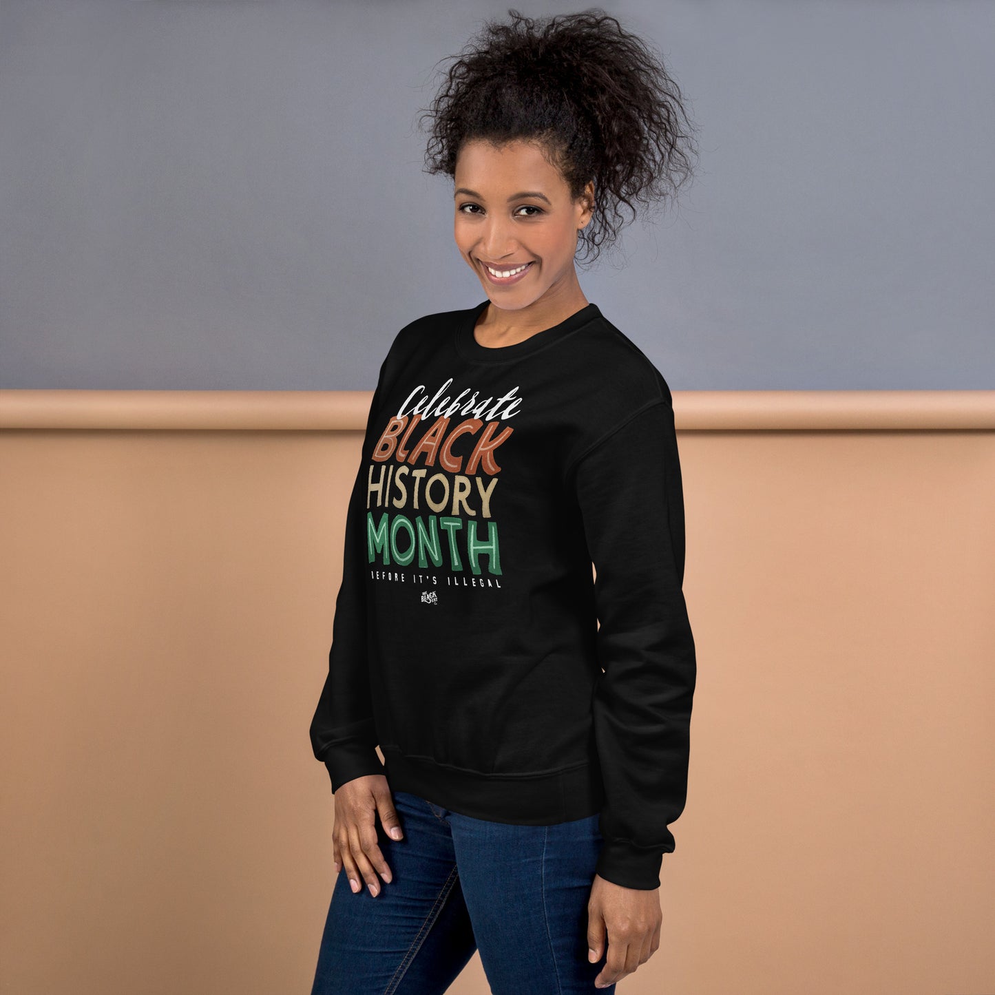 Side view of a woman wearing a black 'Celebrate Black History Month Before It’s Illegal' sweatshirt. Perfect for Black History Month celebrations.