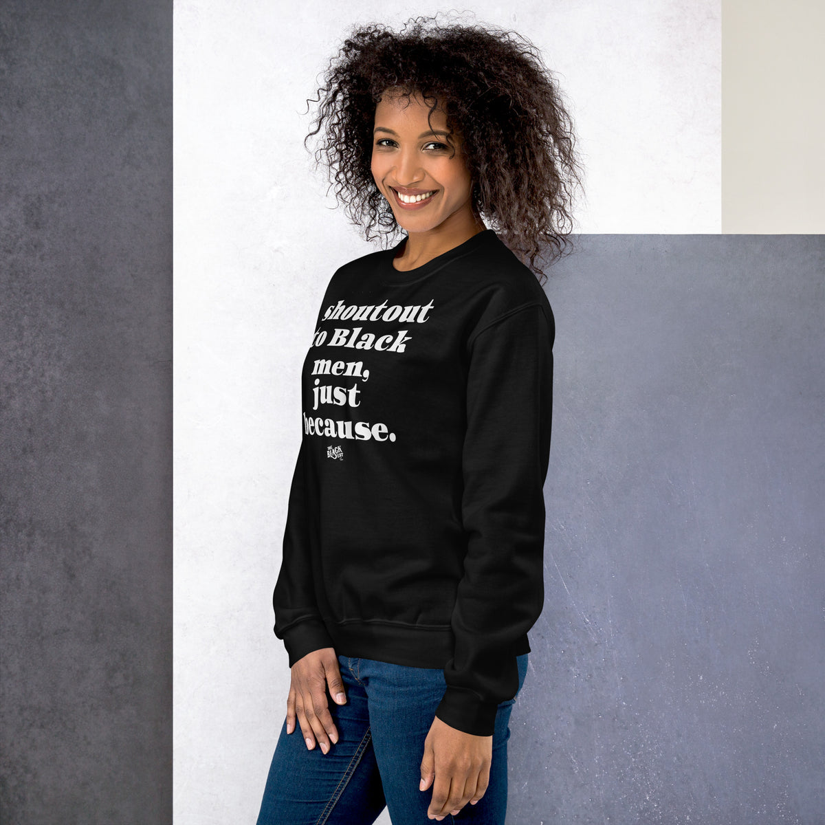 Woman in black sweatshirt with bold white 'Shoutout To Black Men Just Because' message