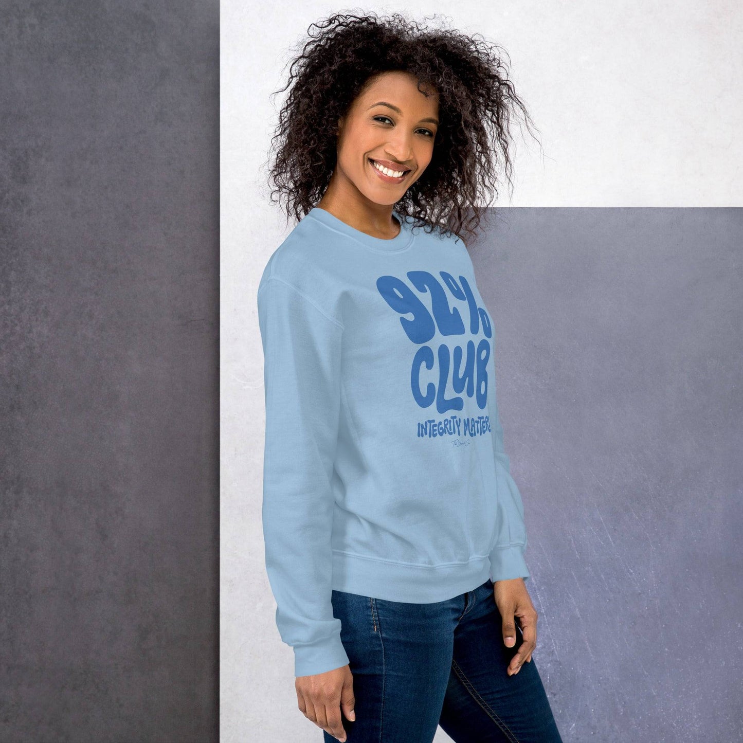 Model wearing the light blue 92% Club Integrity Matters Sweatshirt by TheBlackest Co., paired with jeans for a cozy, casual outfit.