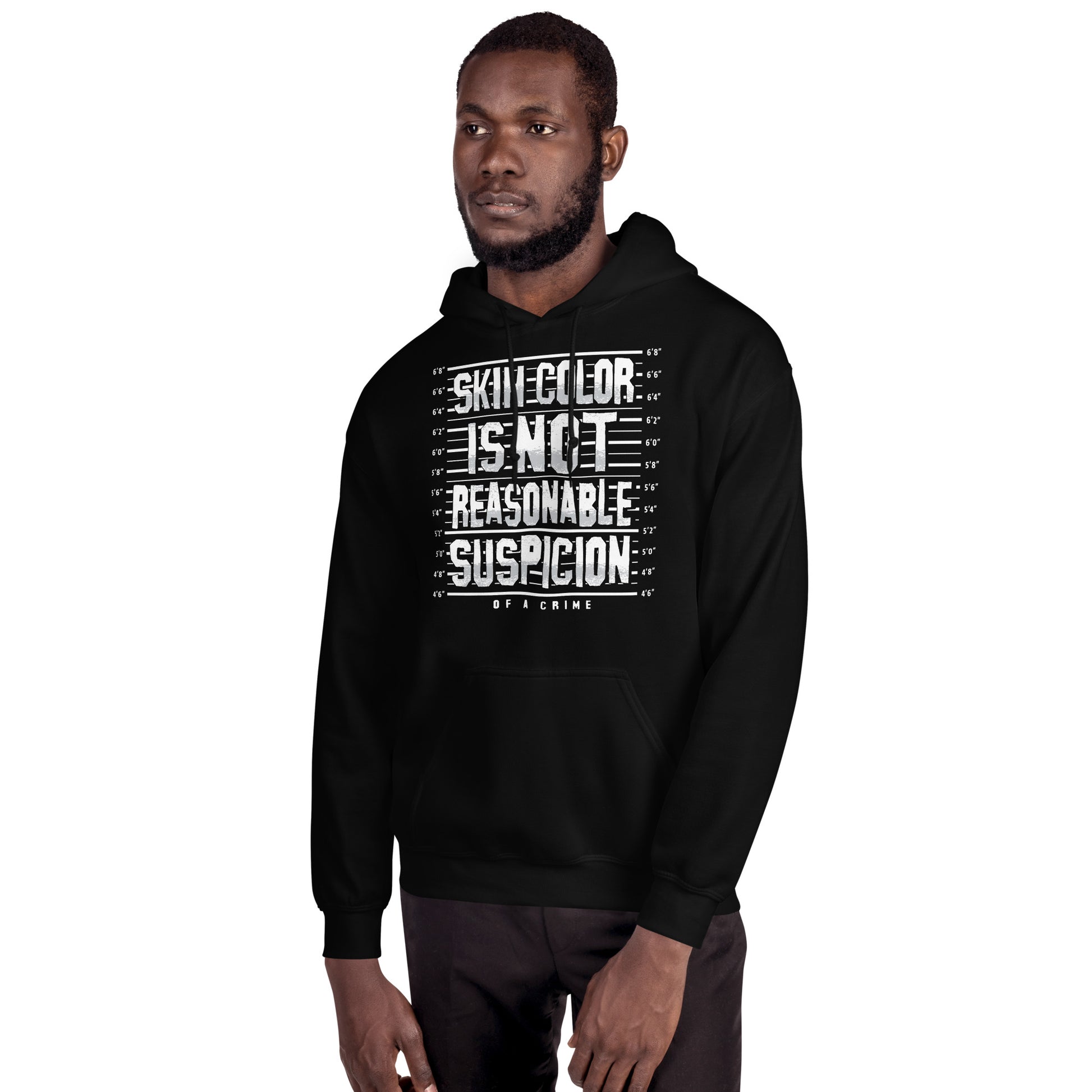 Front view of man modeling Skin Color Is Not A Crime Unisex Hoodie by TheBlackest Co., a cozy black pullover with social justice message.