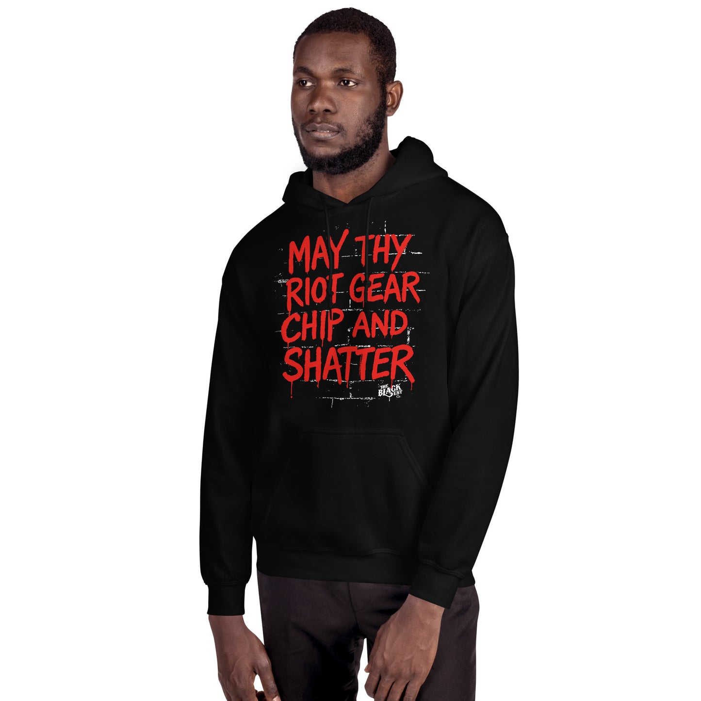 Man wearing May Thy Riot Gear Chip And Shatter Unisex Hoodie by TheBlackest Co., showcasing bold activist message in red on black pullover.