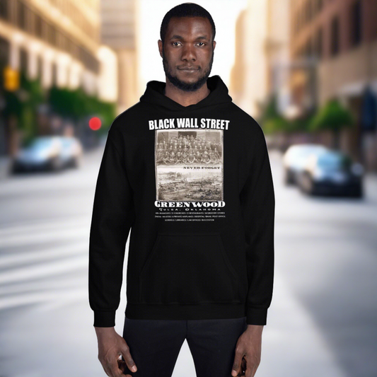 man in front of a blurred city street in a black pullover hoodie with writing that says Black Wall Street