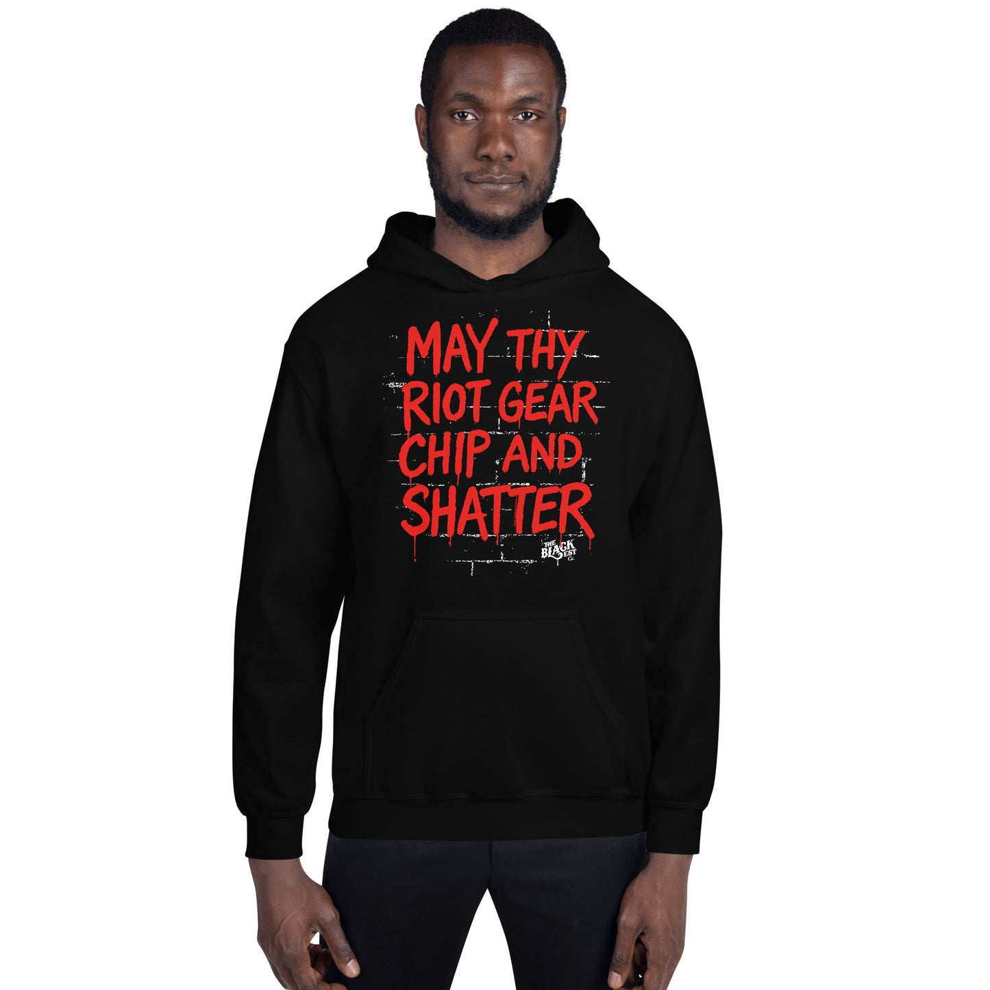 Front view of man in black May Thy Riot Gear Chip And Shatter Unisex Hoodie by TheBlackest Co., showcasing bold red protest text for activist fashion.