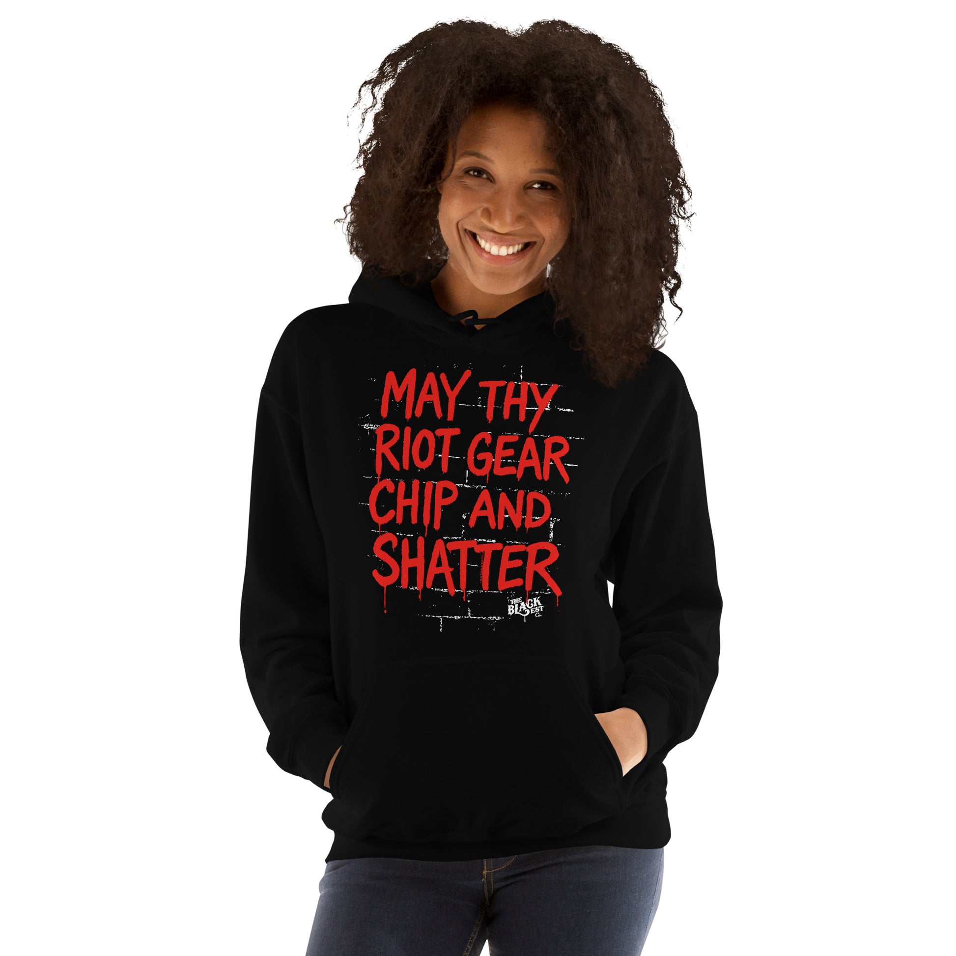 Woman smiling in May Thy Riot Gear Chip And Shatter Unisex Hoodie by TheBlackest Co., a cozy black pullover with strong protest-themed design.