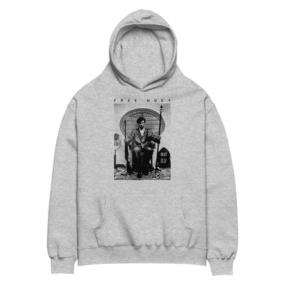 a grey hoodie with a picture of huey p newton sitting on a wicker chair