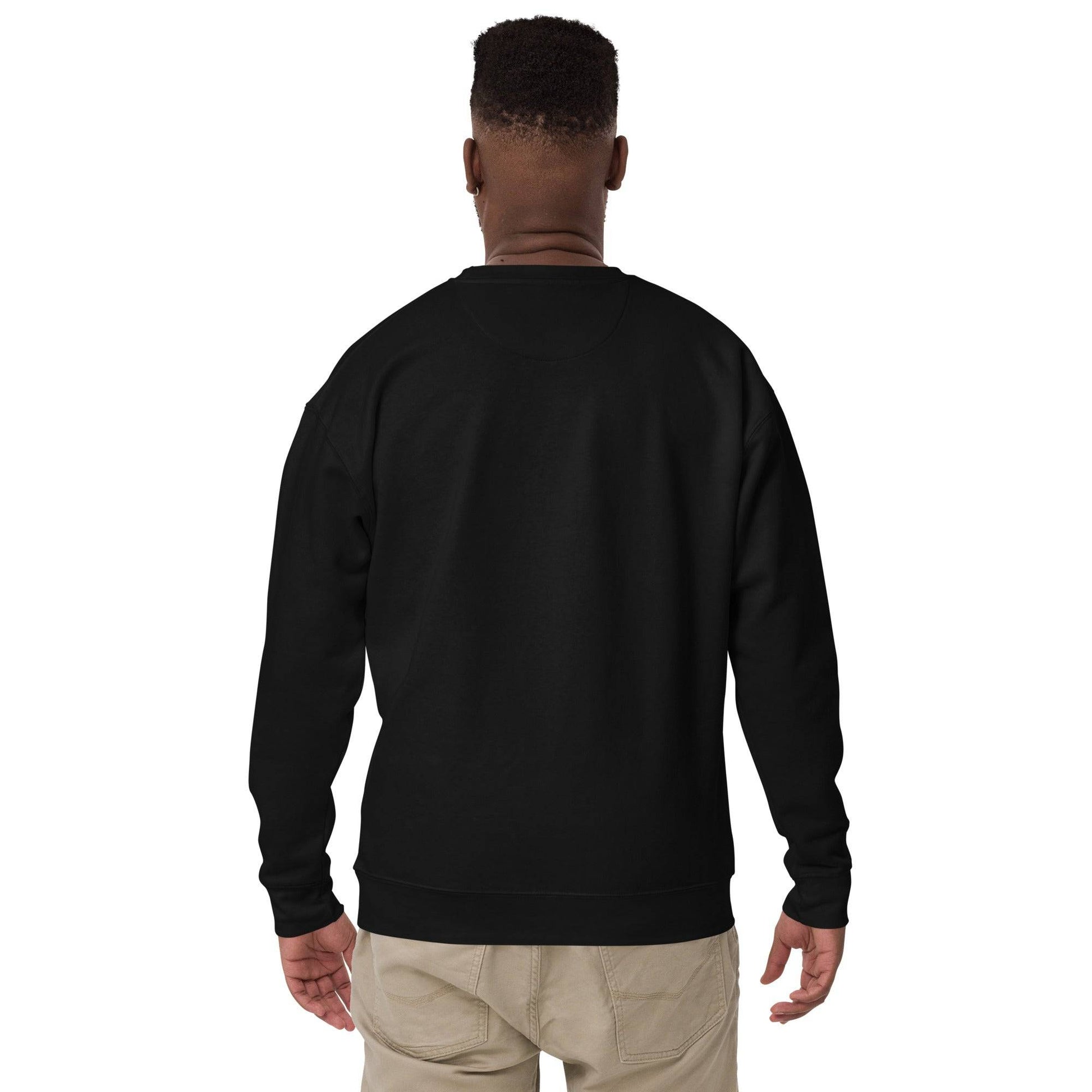 a man wearing a black sweatshirt and khaki pants