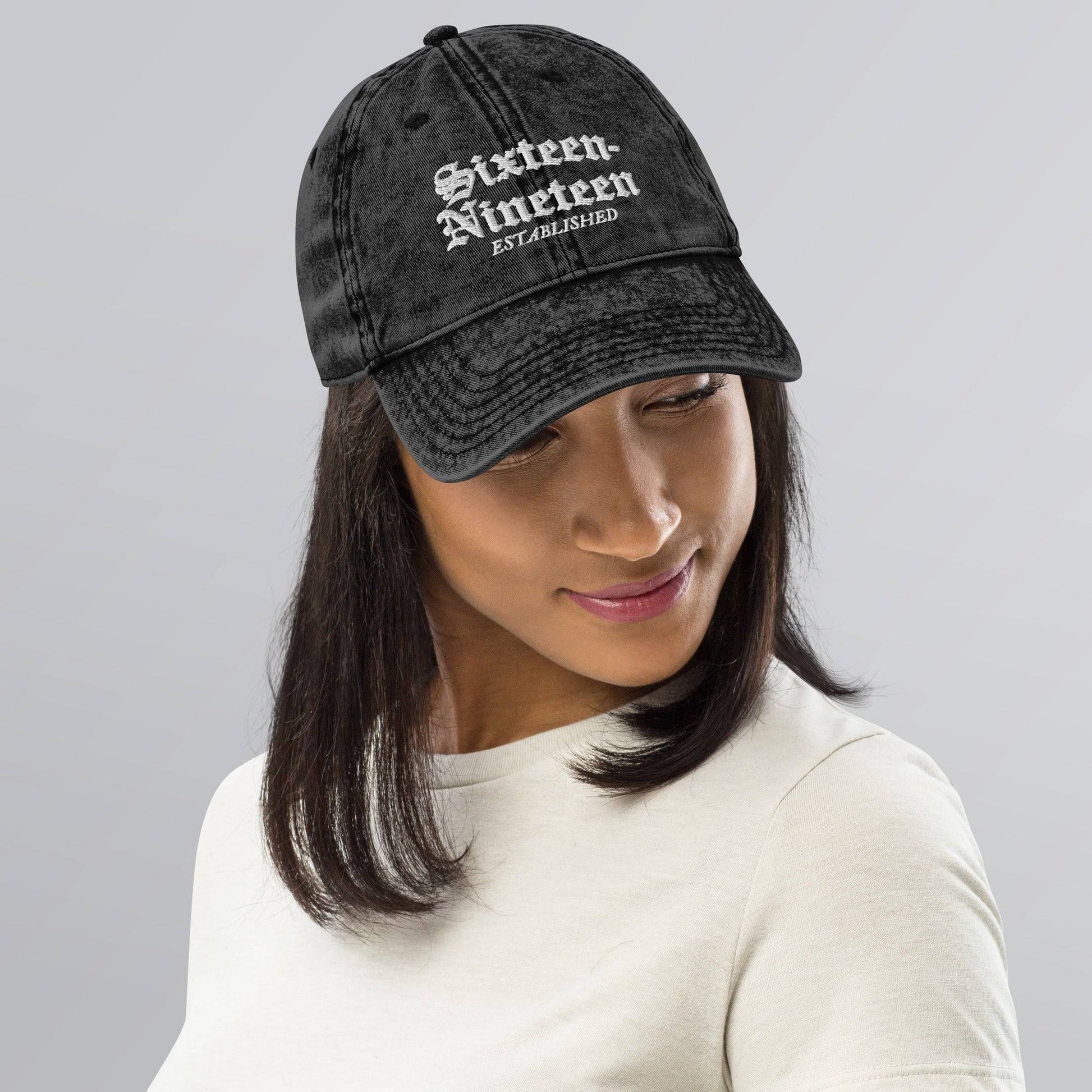 a woman wearing a black hat with white lettering