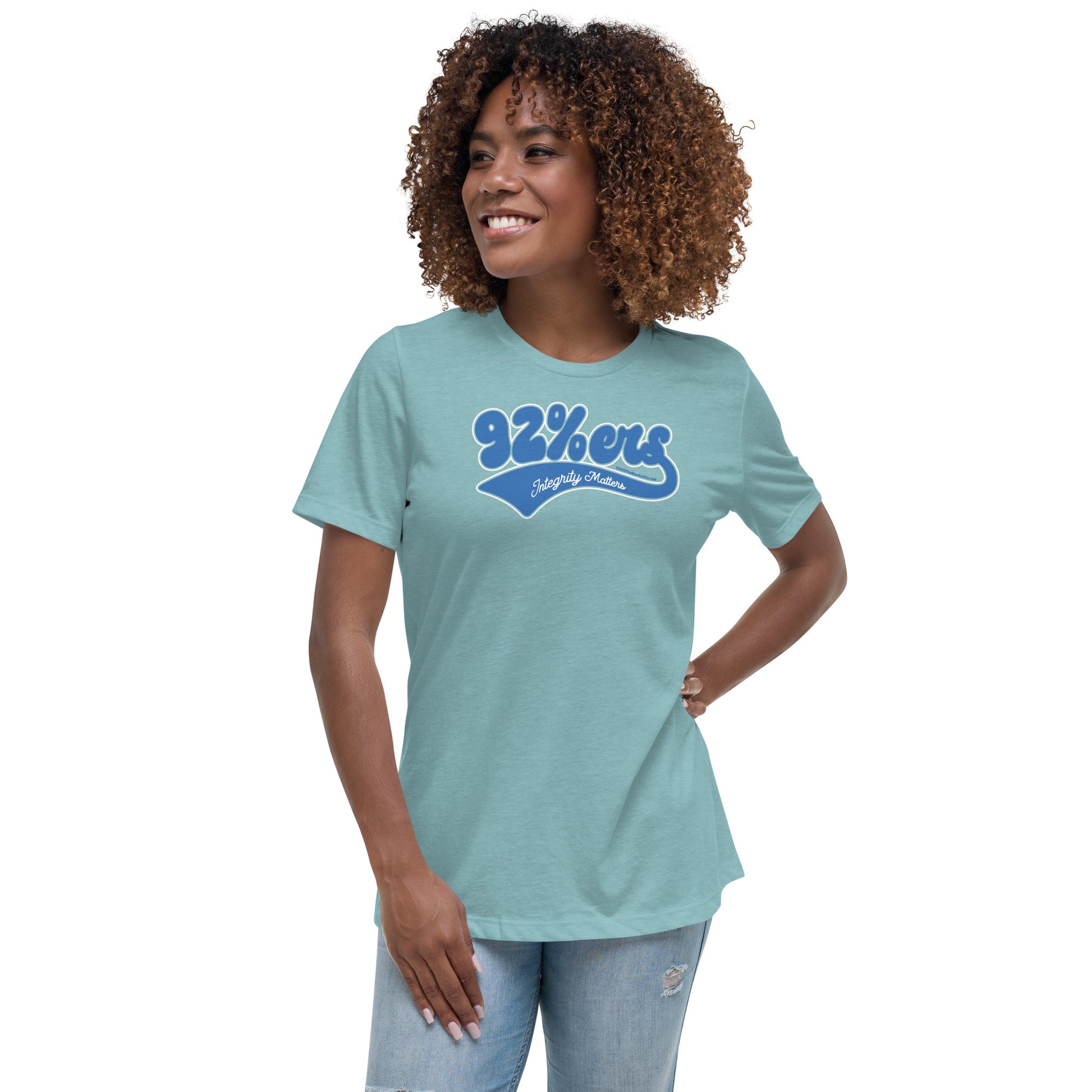 Woman in a light teal '92 Percenter Integrity Matters' relaxed t-shirt styled with light blue jeans, fresh and casual.