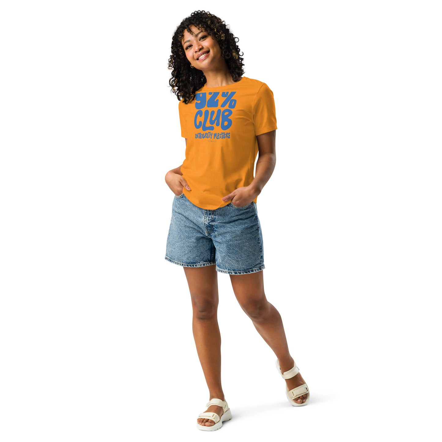 Model wearing a gold 92% Club Women's Relaxed T-Shirt by TheBlackest Co., paired with denim shorts, featuring bold blue text '92% Club Integrity Matters.'