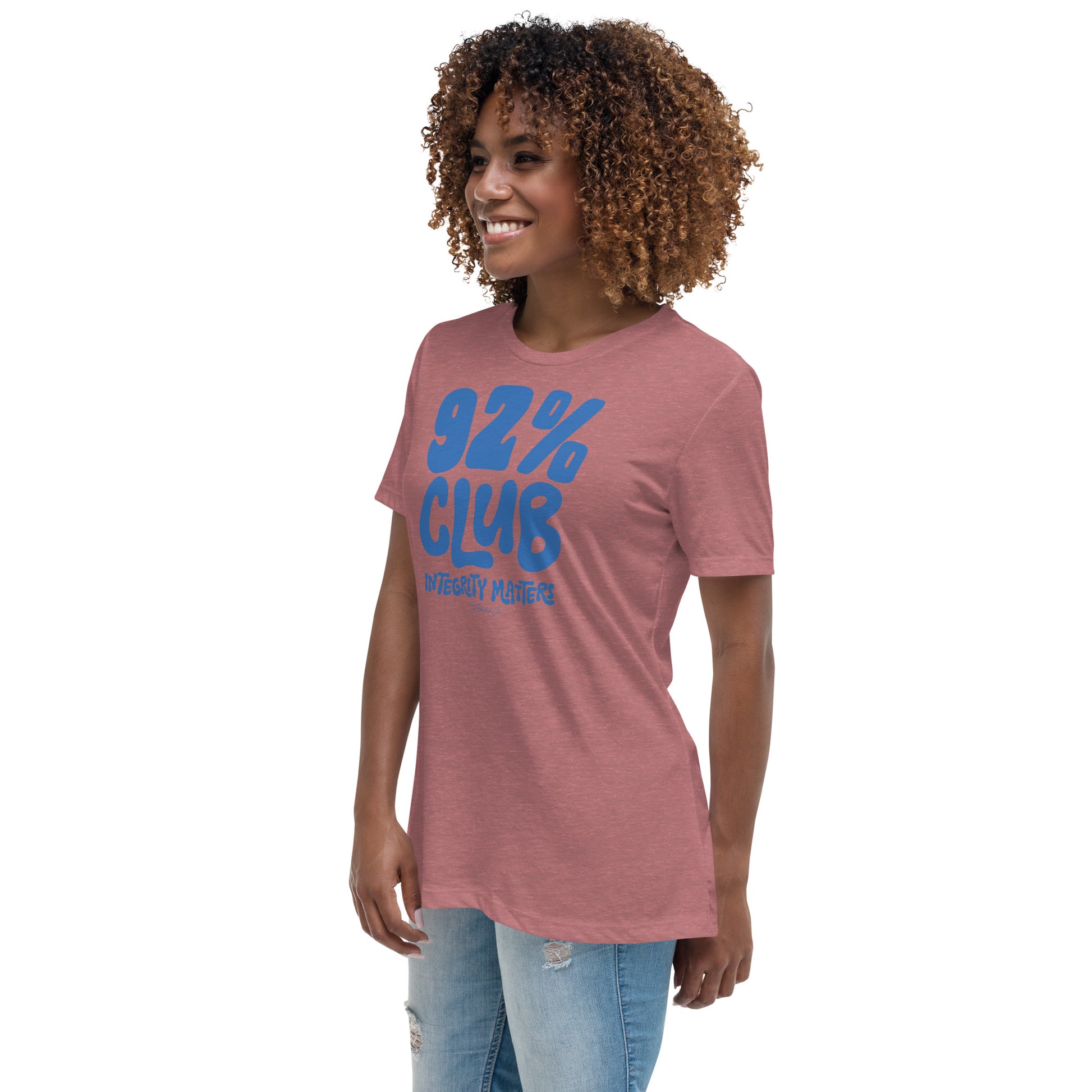 Model wearing a heather mauve 92% Club Women's Relaxed T-Shirt by TheBlackest Co., featuring bold blue text '92% Club Integrity Matters.'