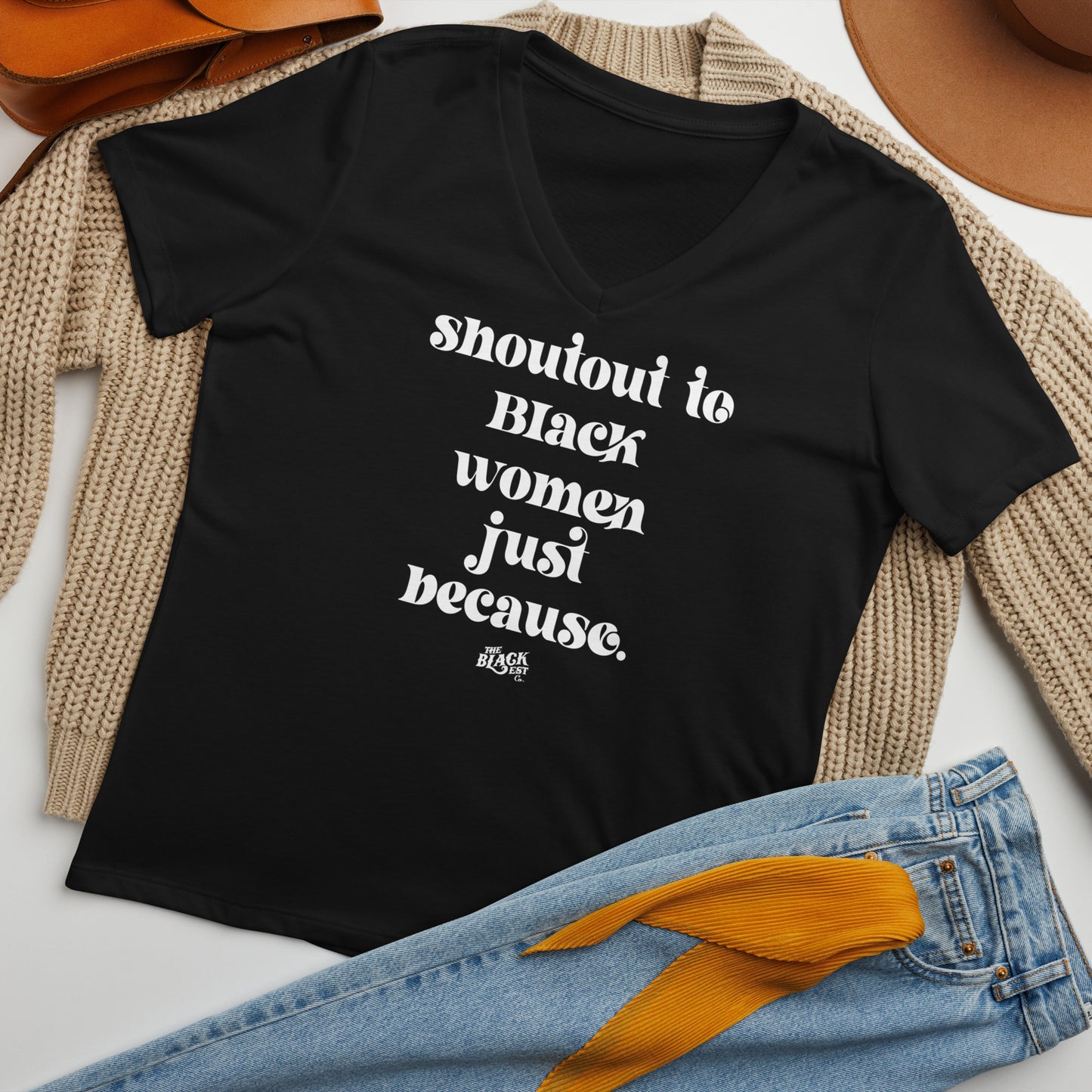 Flat lay of black Shoutout To Black Women Just Because V-neck T-shirt styled with cozy cardigan and accessories, ideal for women's fashion inspiration.