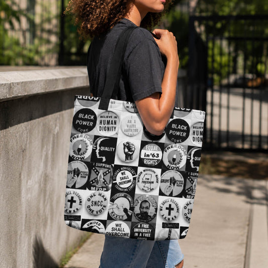 young lady holding Black and white protest art tote bag covered with civil rights protest buttons and slogans