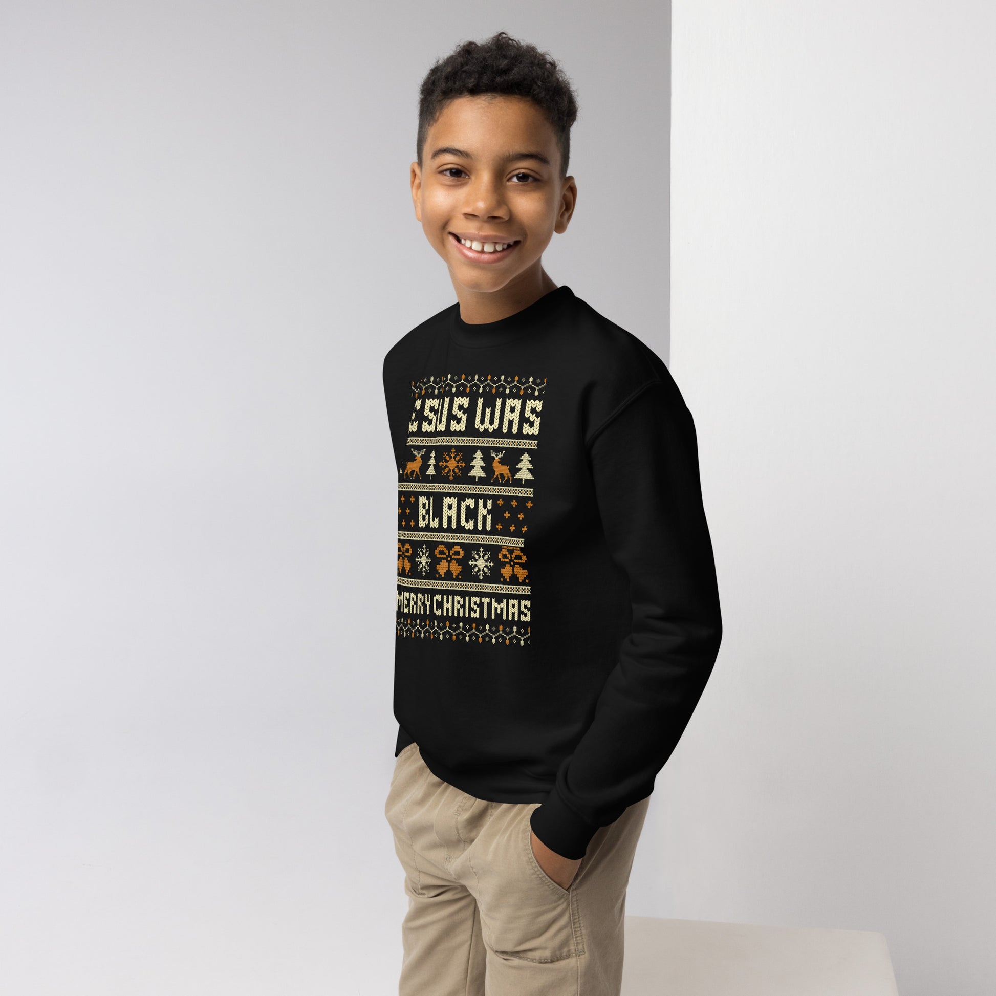 Boy modeling black Youth Jesus Was Black Merry Christmas crewneck sweatshirt, showcasing festive and empowering holiday kids clothing.