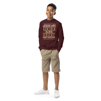 Smiling boy wearing Youth Jesus Was Black Merry Christmas crewneck sweatshirt in maroon, styled for cozy and festive kids holiday wear.